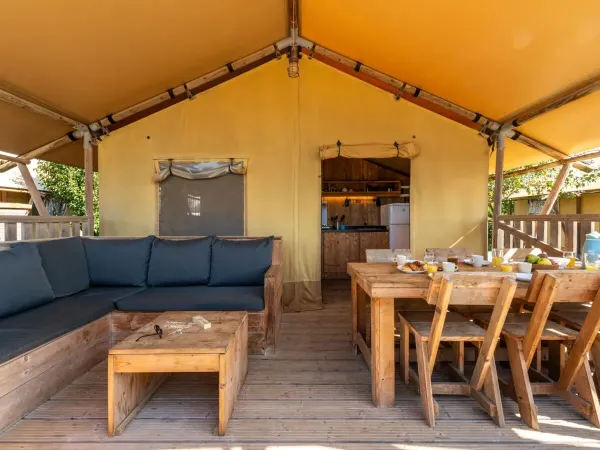 Die Veranda des Roan Lodgetent Luxe ist mit einem Tisch und Stühlen ausgestattet.