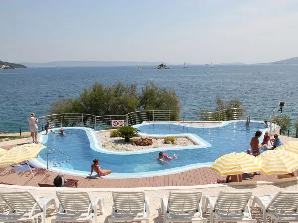 Schwimmbad mit Liegestühlen und Sonnenschirmen auf dem Campingplatz Roan Amadria Park Trogir.