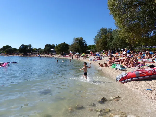 Belebter Strand auf dem Campingplatz Roan Polari.