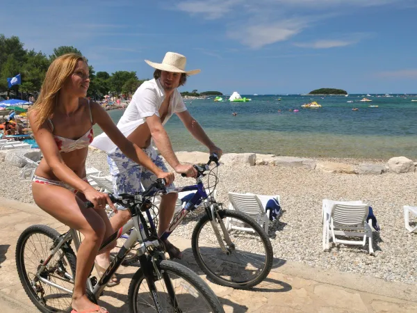 Radfahren entlang des Kieselstrandes auf dem Campingplatz Roan in Valkanela.