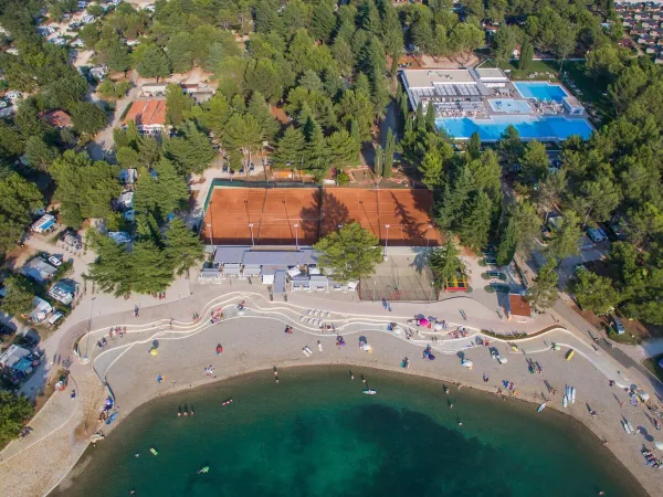 Luftaufnahme des Kieselstrandes und der Strandbar auf dem Campingplatz Roan Valkanela.