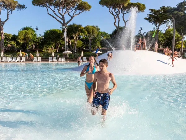 Kinder toben durch das Lagunenbecken des Campingplatzes Park Albatros in Roan.