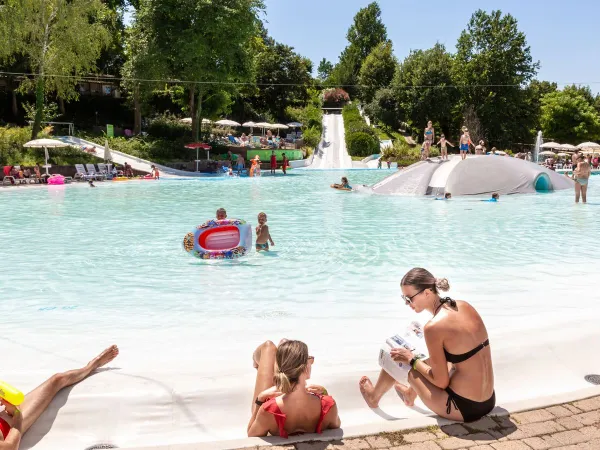 Eltern und Kinder genießen den Lagunenpool auf dem Campingplatz Roan in Altomincio.