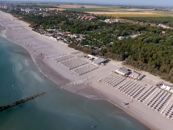 Drohnenaufnahme vom Strand des Roan-Campingplatzes Adriano Village.