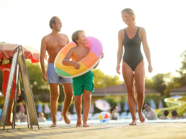 Vater, Mutter und Kind am Pool des Campingplatzes Roan.