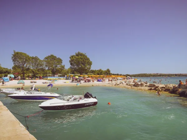 Strand mit Steg und Booten auf dem Campingplatz Roan Bi Village.