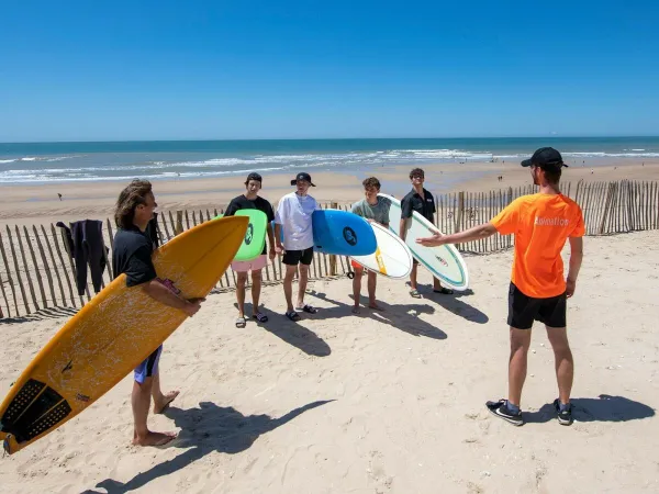 Surfen am Sandstrand des Campingplatzes Roan Atlantic Club Montalivet.