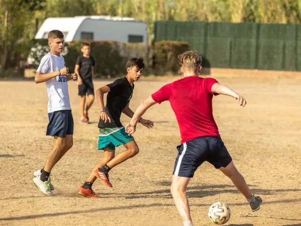 Kinder spielen Fußball auf dem Roan-Campingplatz Playa Brava.