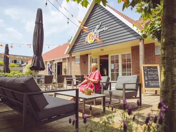 Trinkende Menschen auf der Terrasse des Campingplatzes 't Veld.