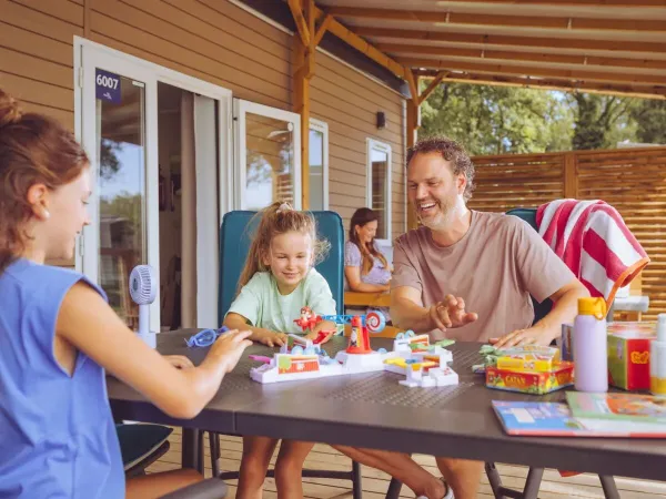 Die Familie spielt ein Spiel auf der Veranda.