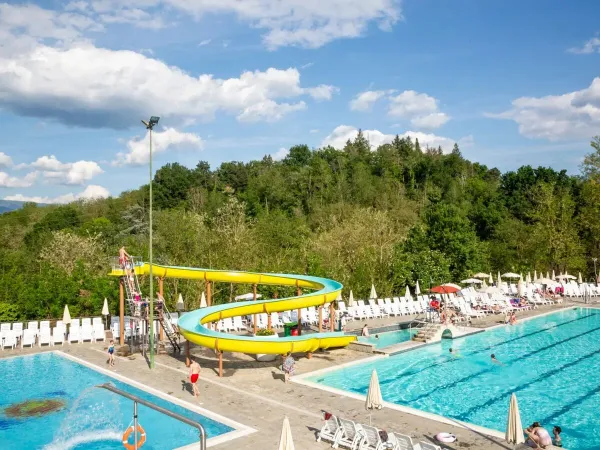 Sonnenterrasse mit halb-olympischem Pool und Rutsche auf dem Campingplatz Roan hu Norcenni Girasole village.
