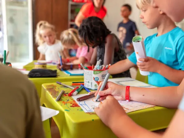 Kinder zeichnen im Kids Club auf dem Campingplatz Roan Château de Fonrives.