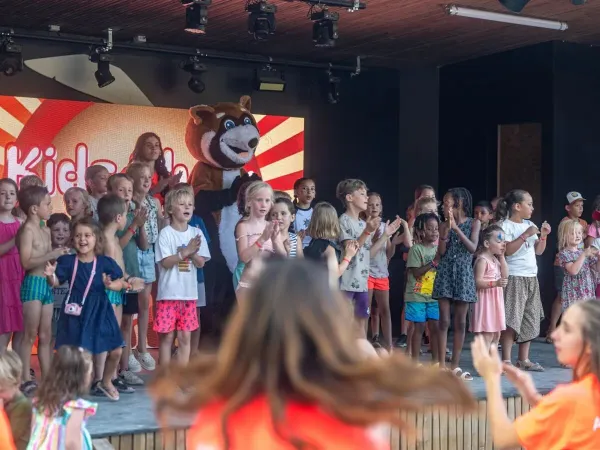 Fröhlich singende Kinder auf der Bühne des Campingplatzes Roan Château de Fonrives.