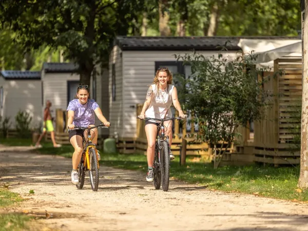 2 Damen radeln über den Roan-Campingplatz Château de Galaure.
