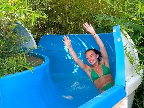 Mädchen rutscht die Wasserrutsche auf dem Campingplatz Roan Méditerranée Plage hinunter.