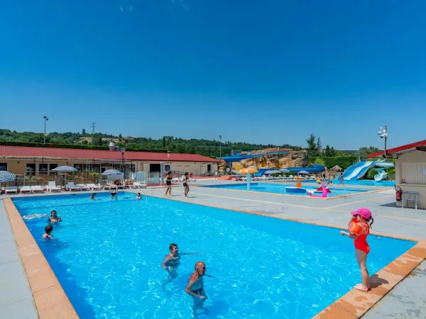 Familien baden im Pool des Campingplatzes Roan Chateau de Galaure.