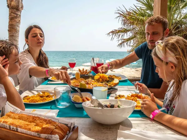 Eine Familie isst am Strand auf dem Roan-Campingplatz Alannia Els Prats.