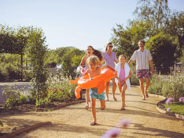 Familie auf dem Weg zum Schwimmbad.