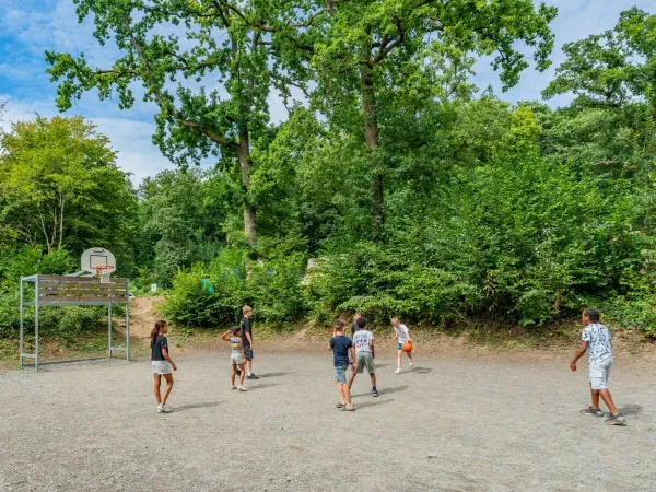Kinder spielen eine Partie Basketball auf dem Campingplatz Le Lac des Vieilles Forges in Roan.