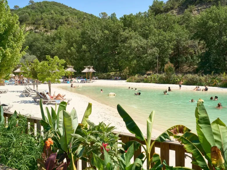 Lagunenpool mit Sandstrand und Sonnenliegen auf dem Campingplatz Roan Verdon Parc.
